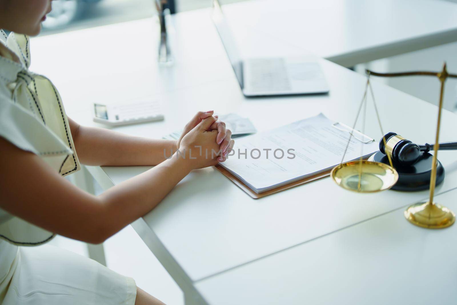 Law and legitimacy, woman holding hands expressing concern during litigation consultation with lawyer by Manastrong