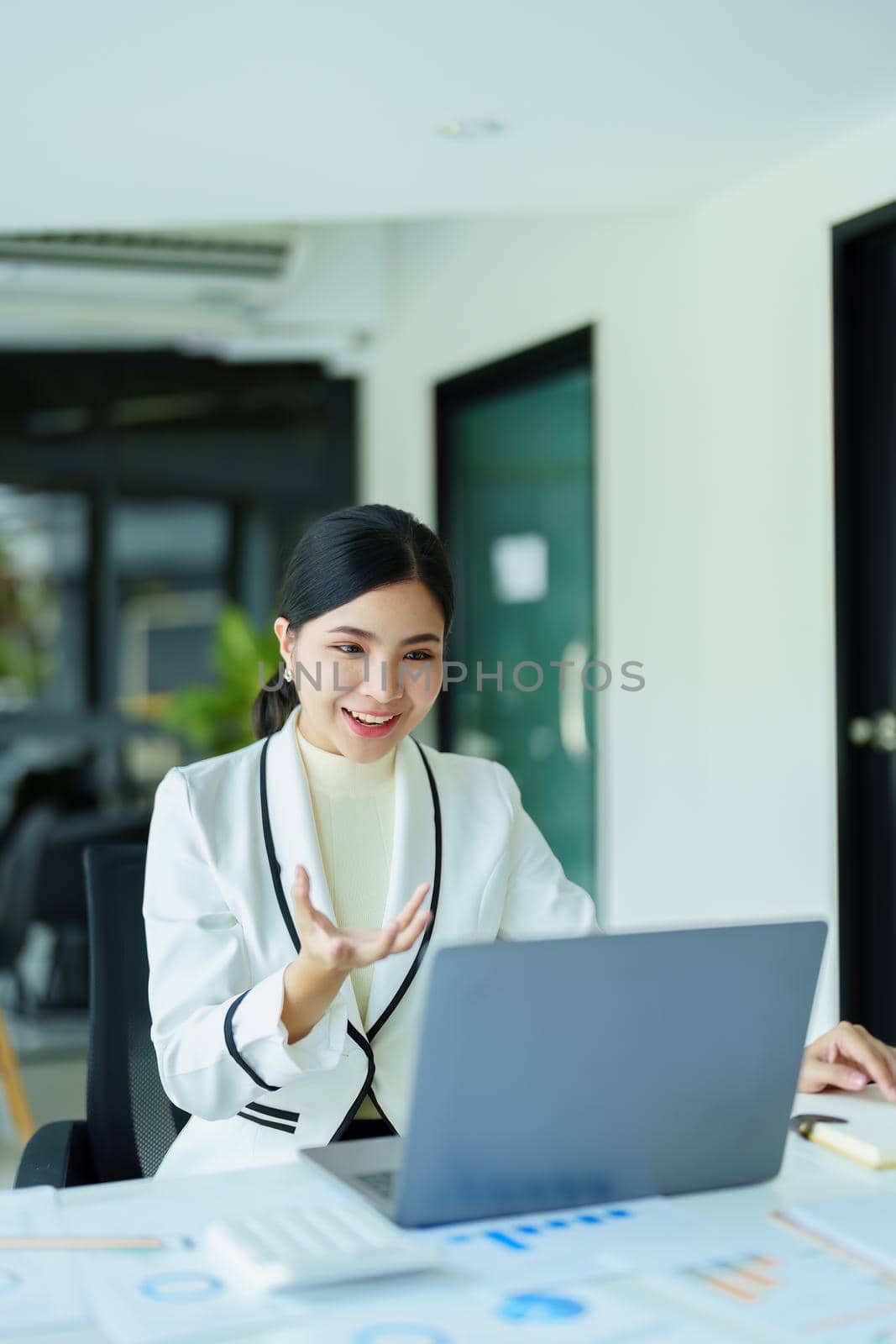 A portrait of a female employee using a computer video conferencing to discuss work through the Internet network.