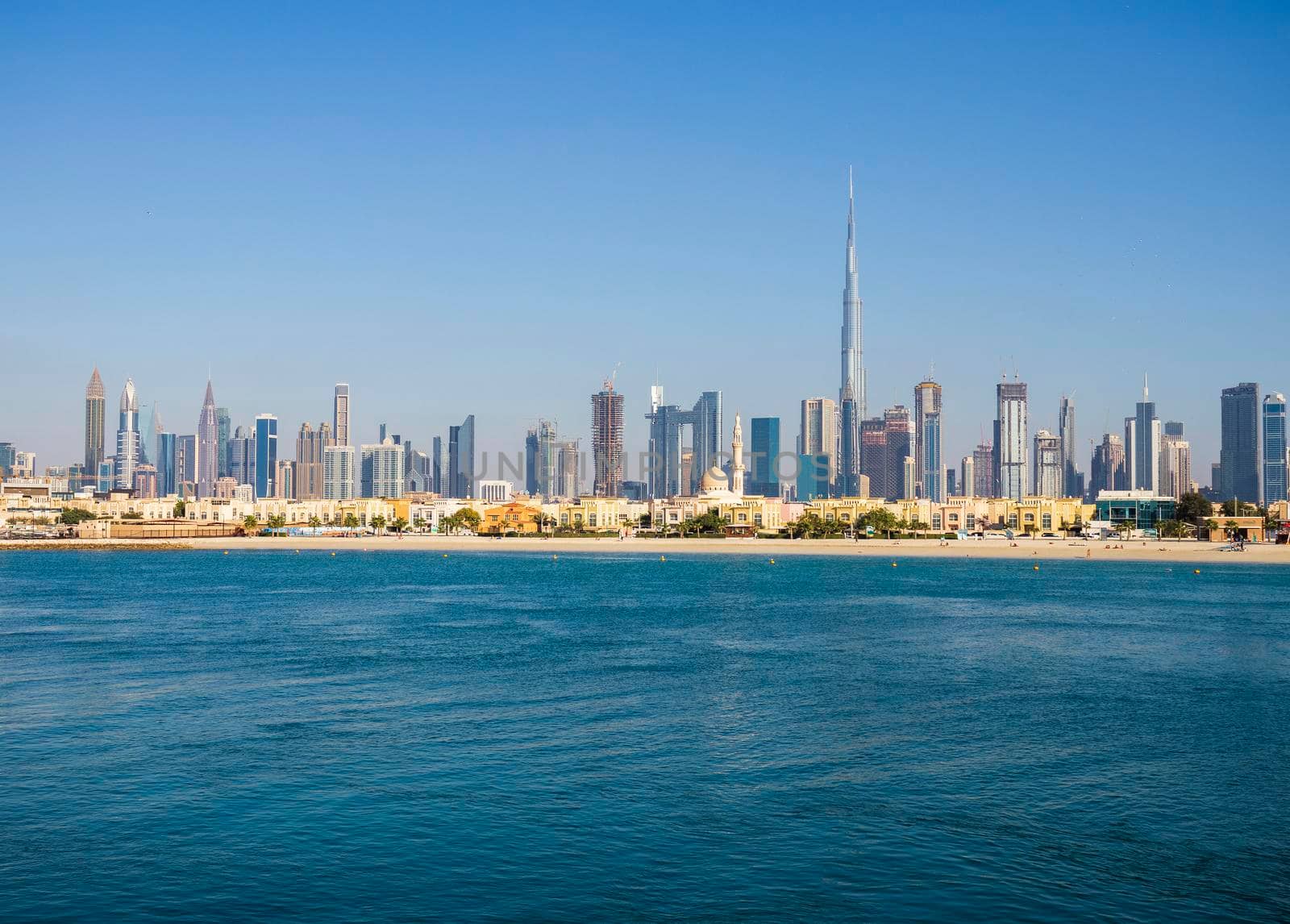 Dubai, UAE - 02.27.2021 Dubai public beach with city skyline on background.