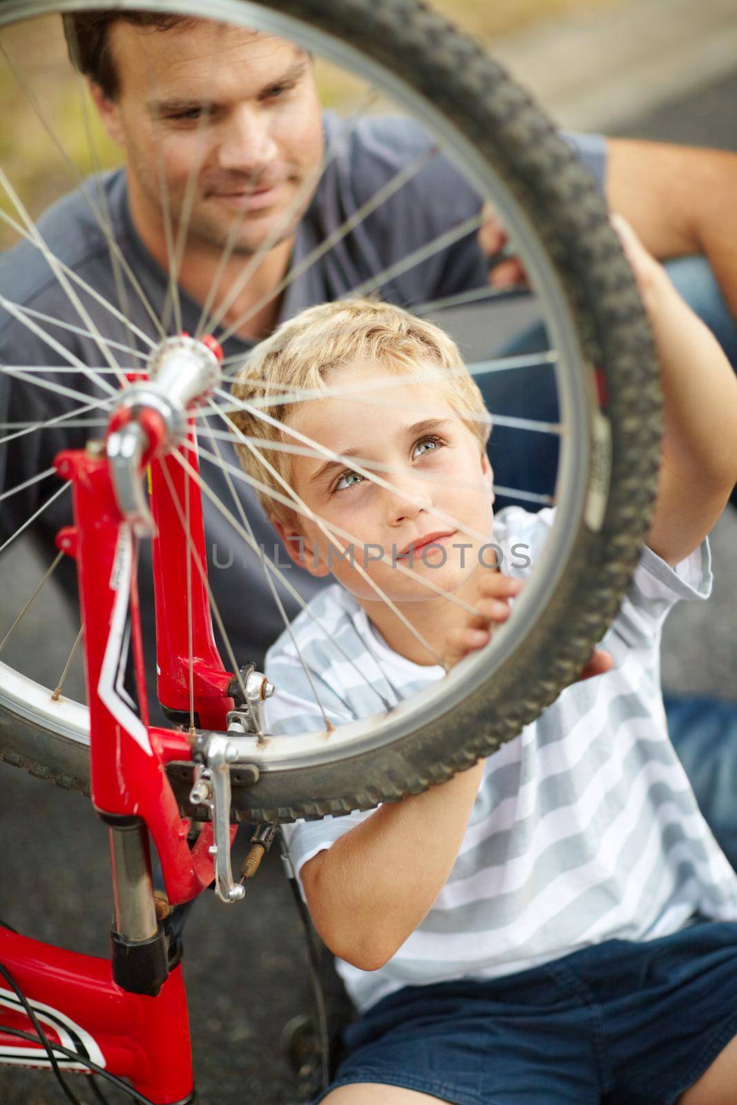A new learnt skill he wont forget. Young father teaching his son how to change a bike puncture