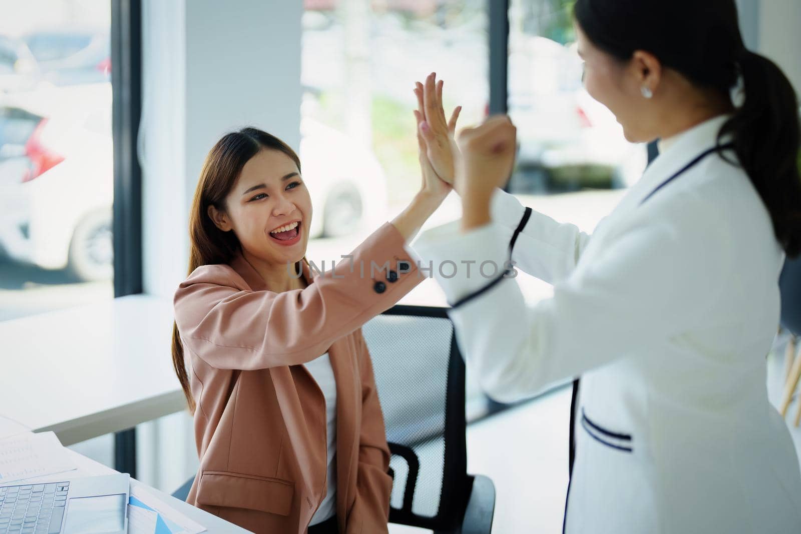 A portrait of two beautiful female employees posing together after sales hit their targets.