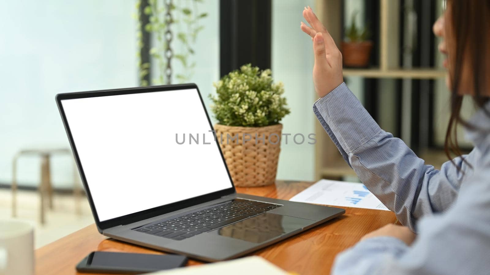 Side view of young woman making video call , watching online webinar on laptop computer.