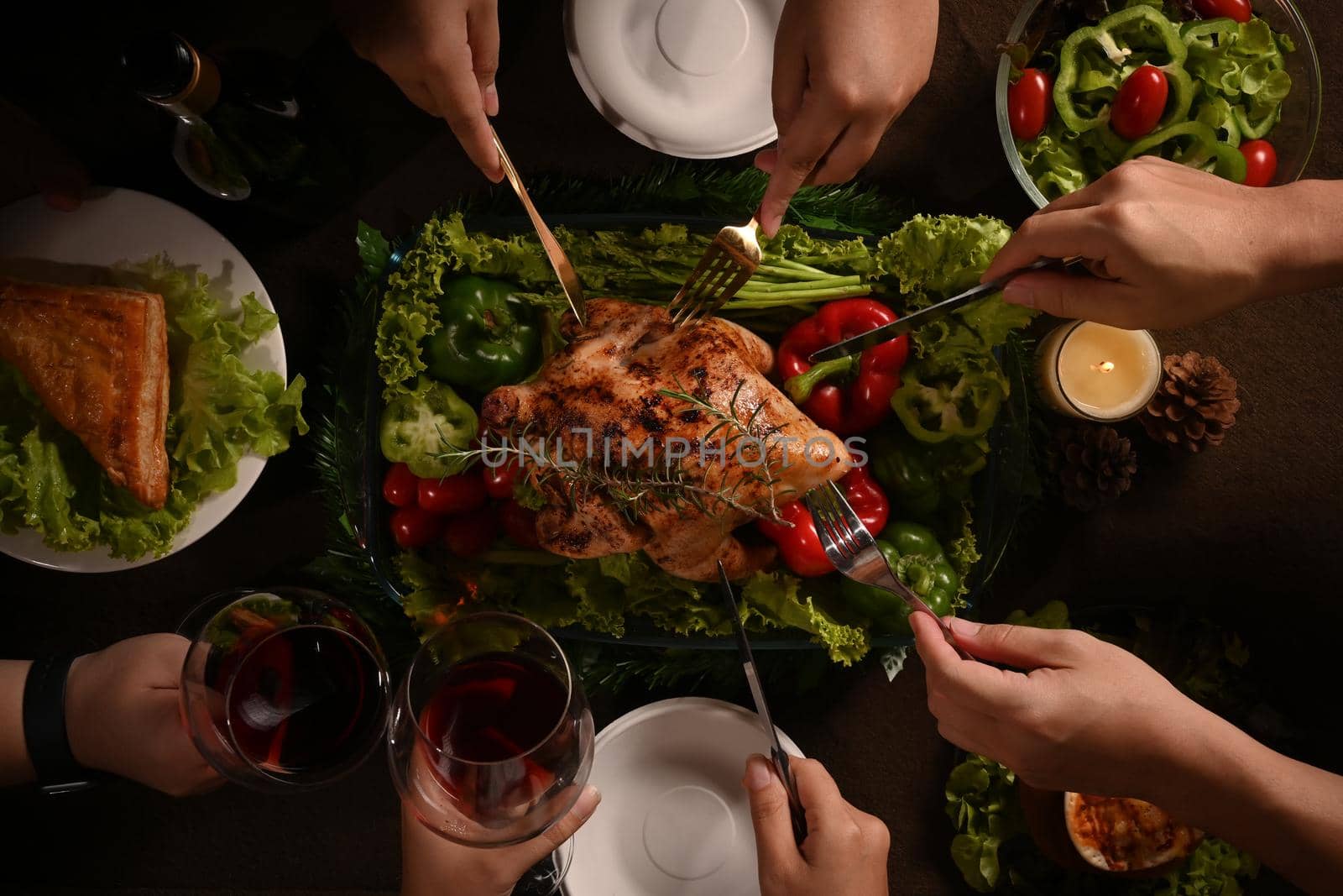 From above view group of friends or family enjoy eating roast turkey, Thanksgiving meal together. Celebration, holidays and Christmas concept.