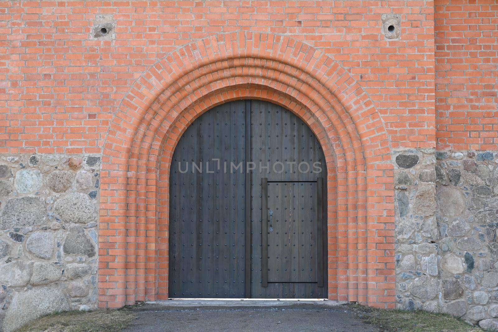 Doors in a brick wall in an old building by chichaevstudio
