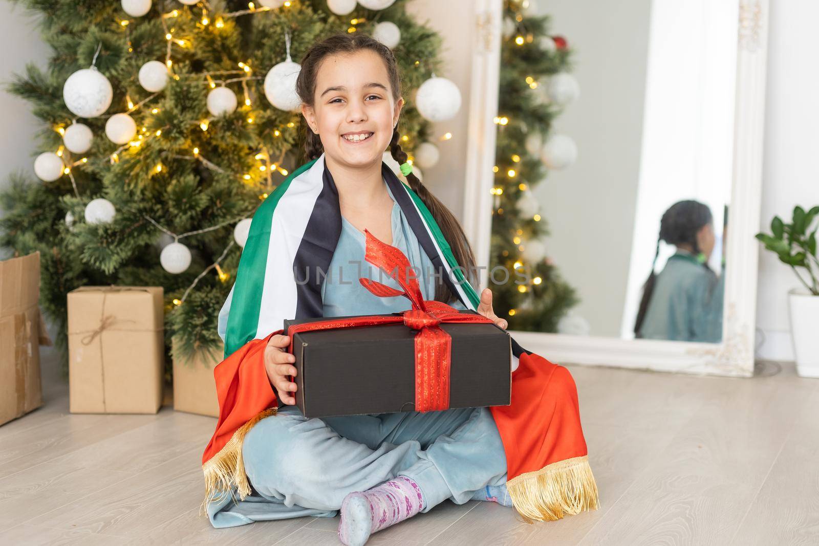 little girl with flag of UAE at christmas
