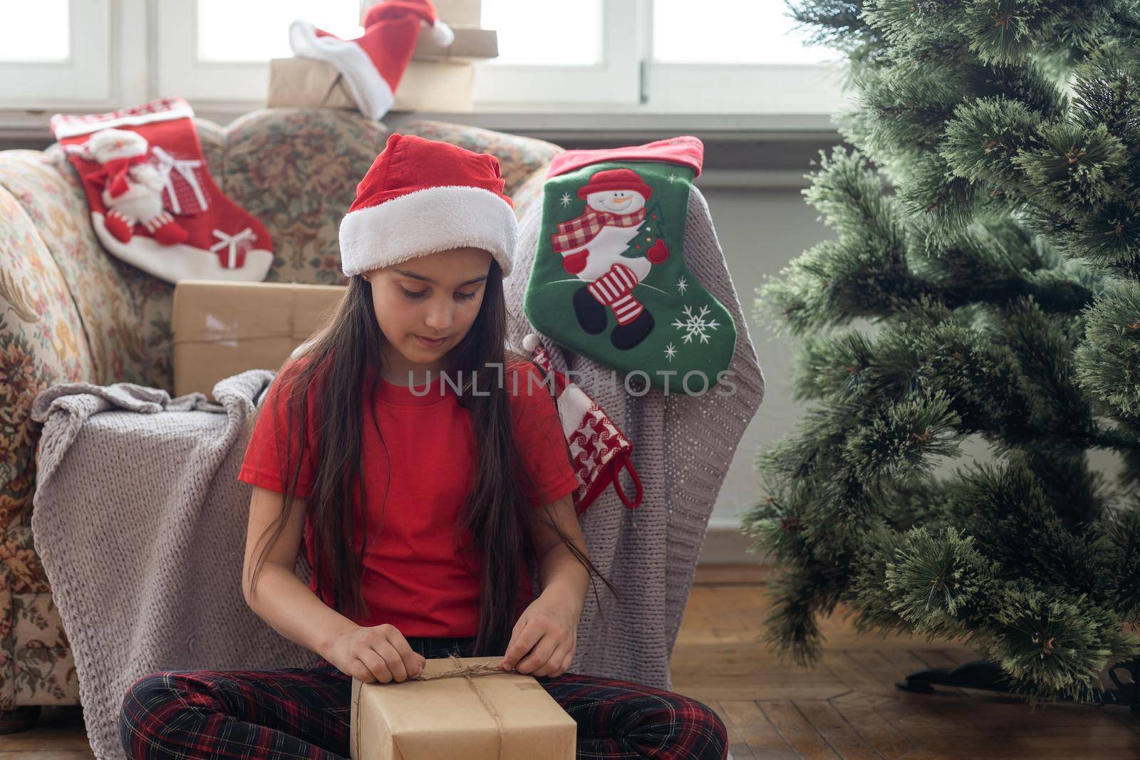 Little cute girl looking inside of glowing Christmas present box.