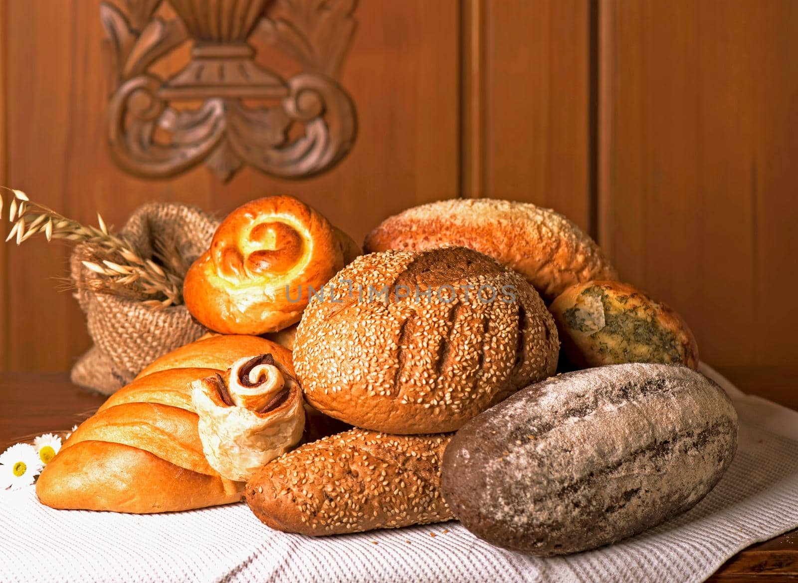 Flour products of various types. Wicker basket with different types of bread and sweet buns on a wooden table. by aprilphoto