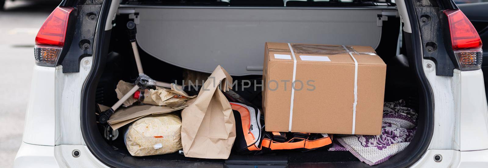 Office moving concept. Cartoon boxes in a car trunk.