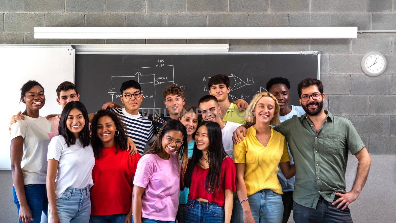 Multiracial teen high school students group class portrait with teacher looking at camera. by Hoverstock