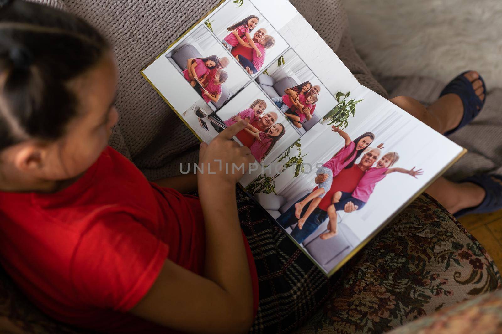 a little girl is holding a photo book by Andelov13