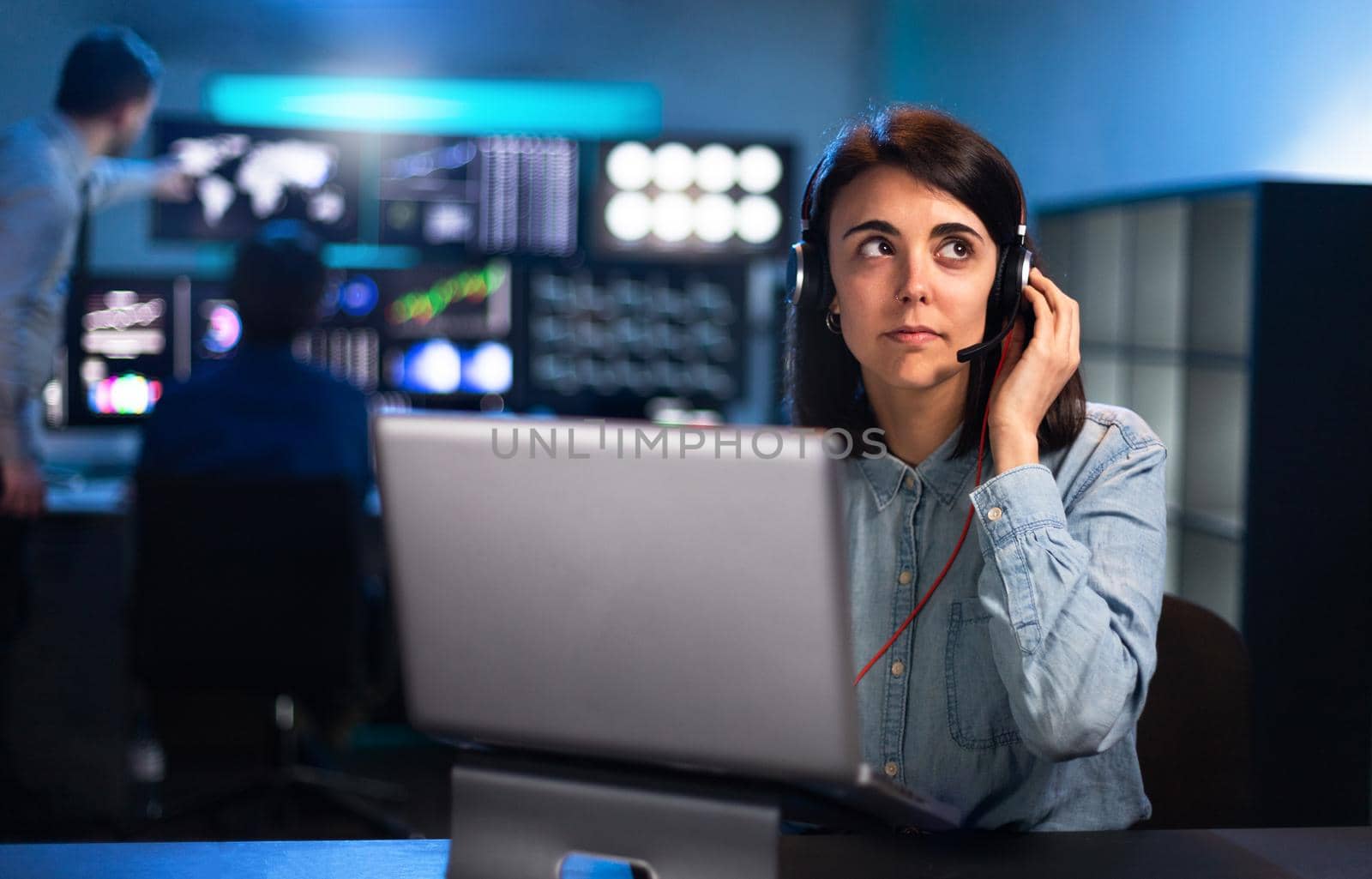 Modern young woman working in financial trading and stock market business. Talking with client with headset. Office