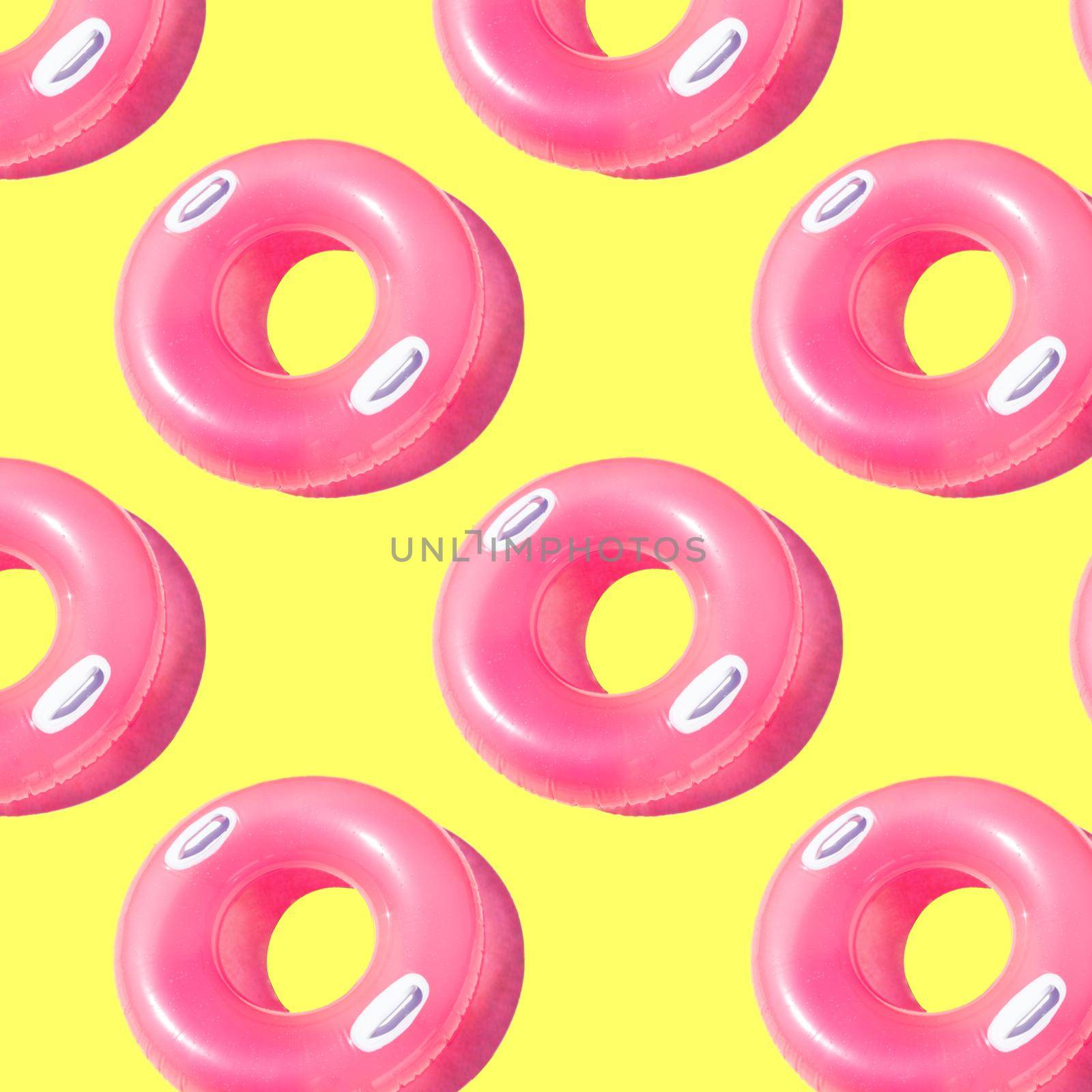 Bright pink inflatable circle with white handles and a shadow on a yellow background pattern