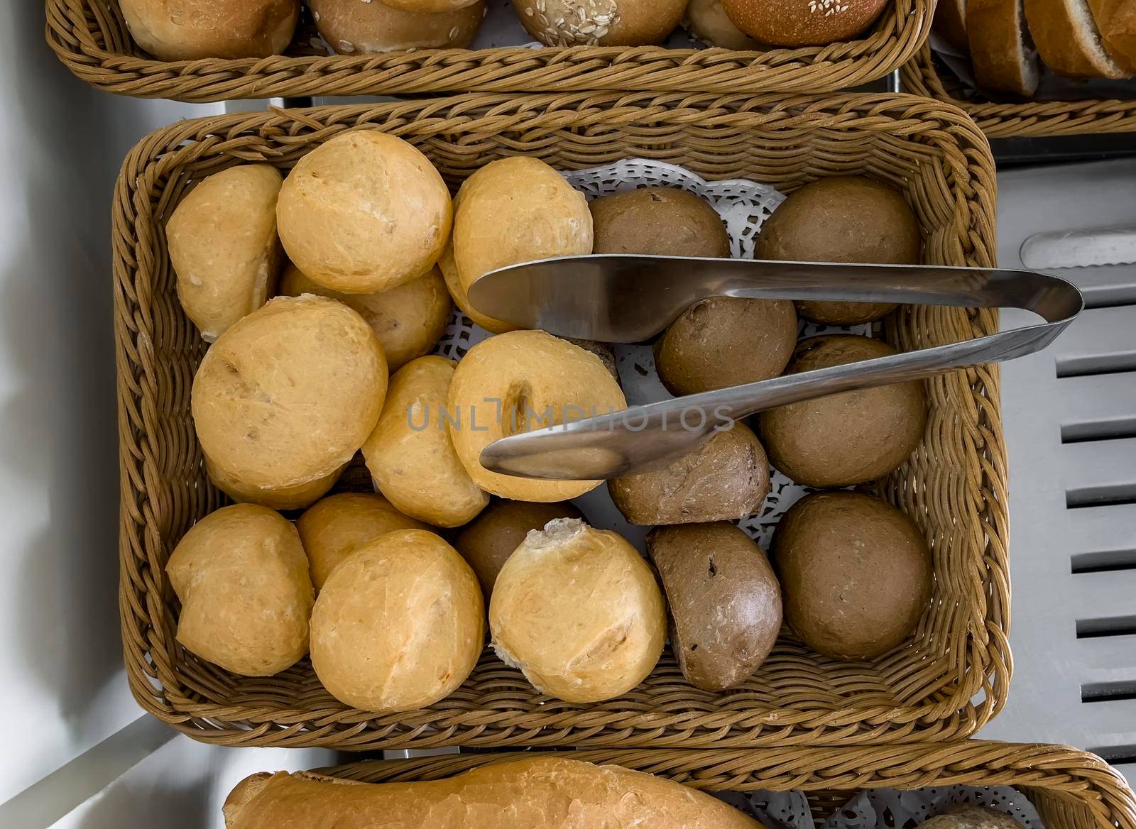 Delicious buns are on the table in a wicker basket. Top view, close-up.