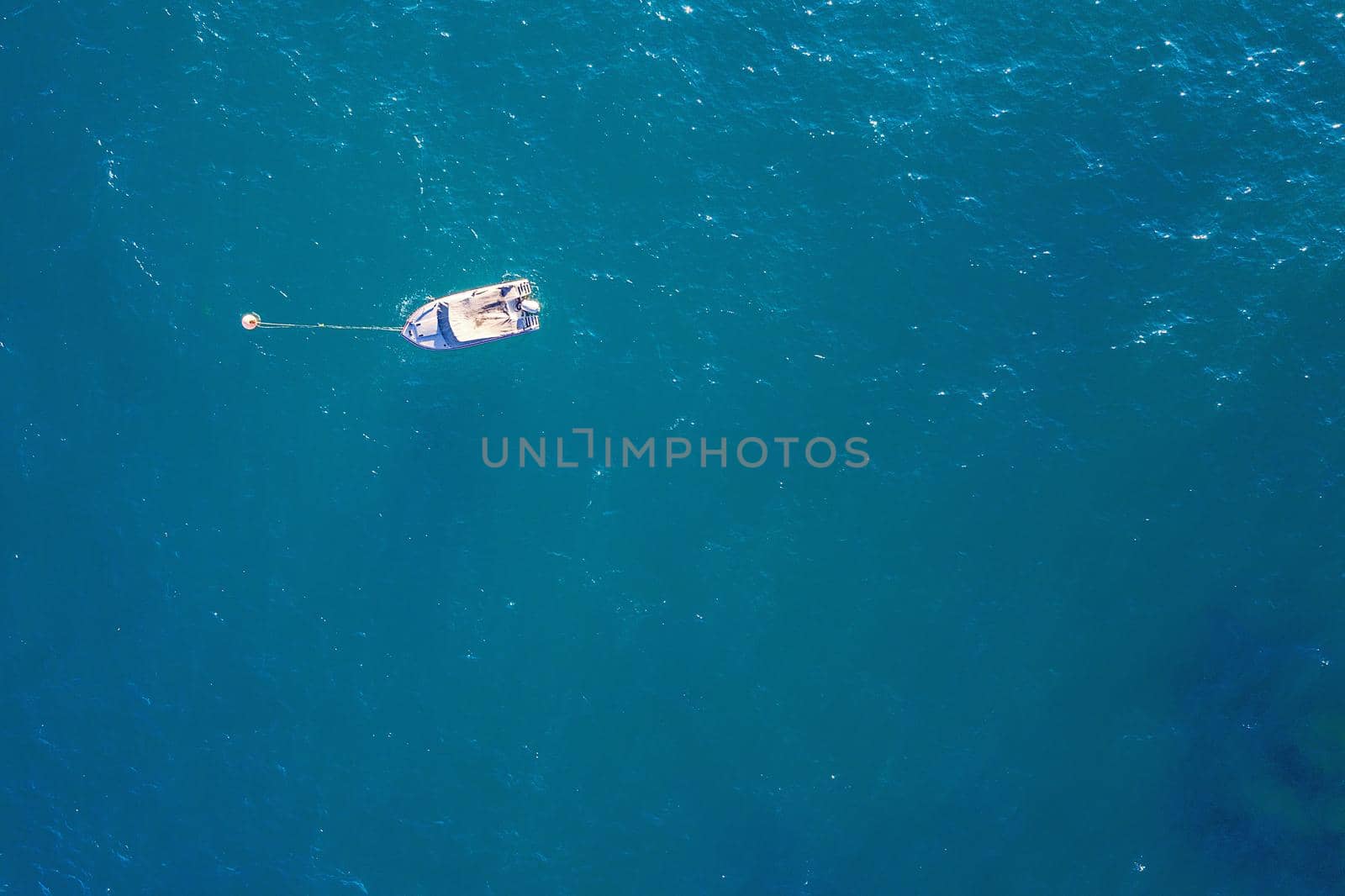 top view of a white boat moored in the blue sea in caribbean tropical beach with turquoise waters. concept of adventure lifestyle and water sports in summer holiday