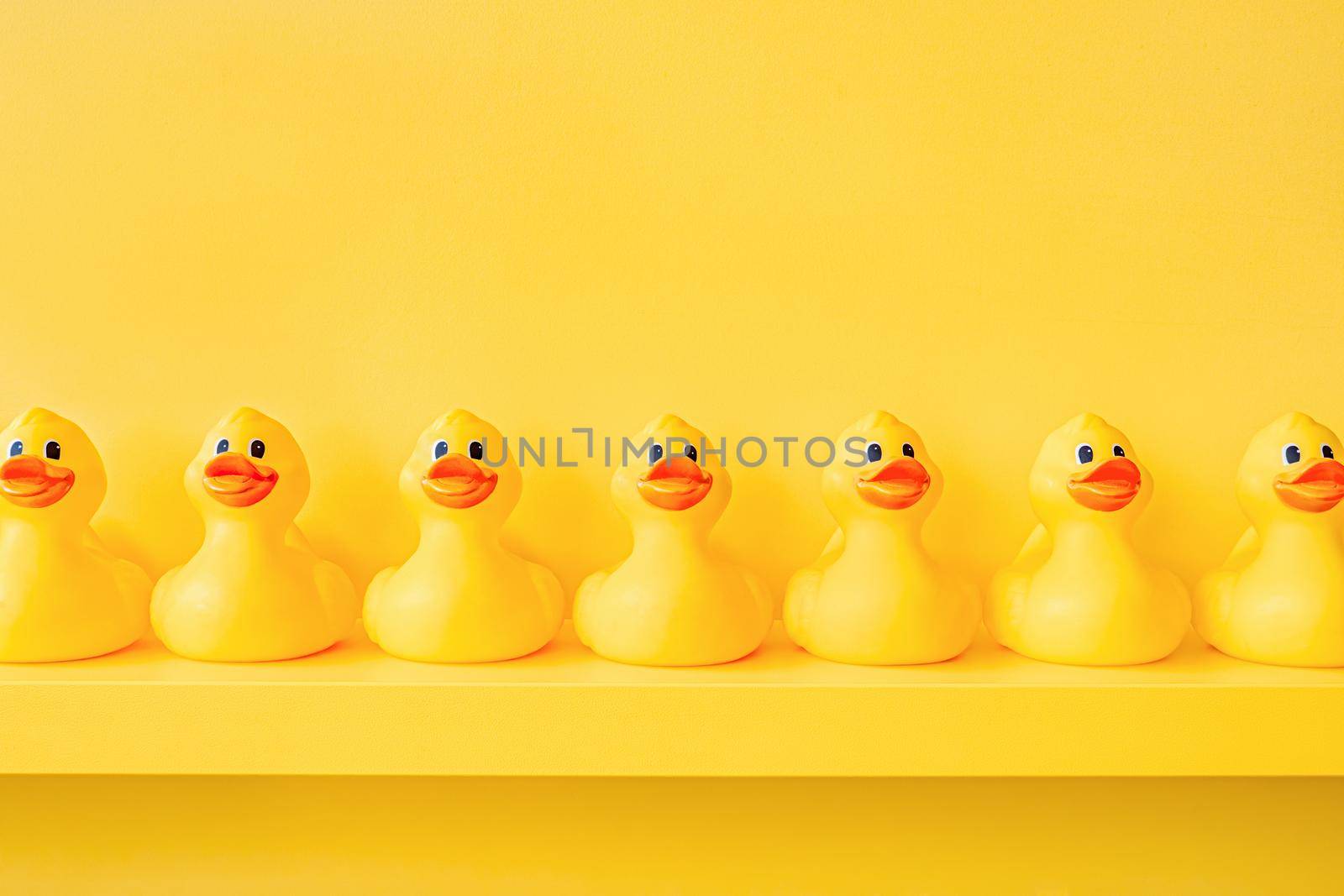 Yellow rubber duck in a line toy design yellow concept team work together. Rubber ducky bath toy background yellow ducks in a row. Rubber duck background team meeting. Community. Teamwork. Cooperation by synel