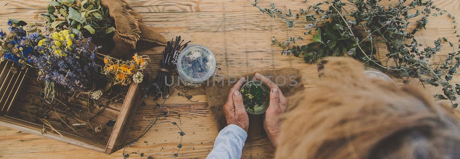 Grandmother makes tea with medicinal herbs. Selective focus. by yanadjana