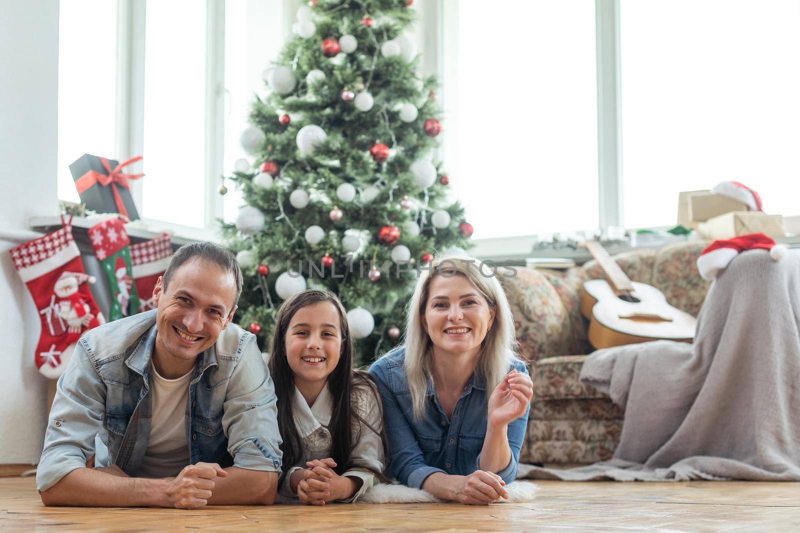 family near the Christmas tree in their living room.