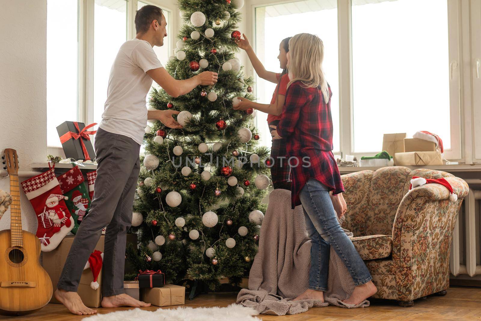 Family decorating a Christmas tree.