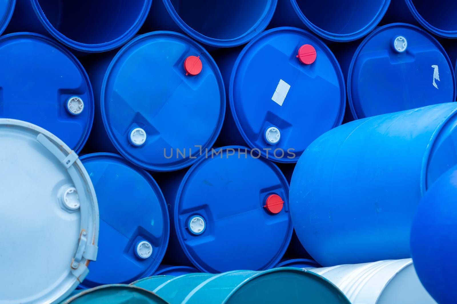 Old chemical barrels. Empty blue chemical drums stack. Steel and plastic oil tank. Toxic waste warehouse. Hazard chemical barrel. Industrial waste in drum. Hazard waste storage in factory.  by Fahroni
