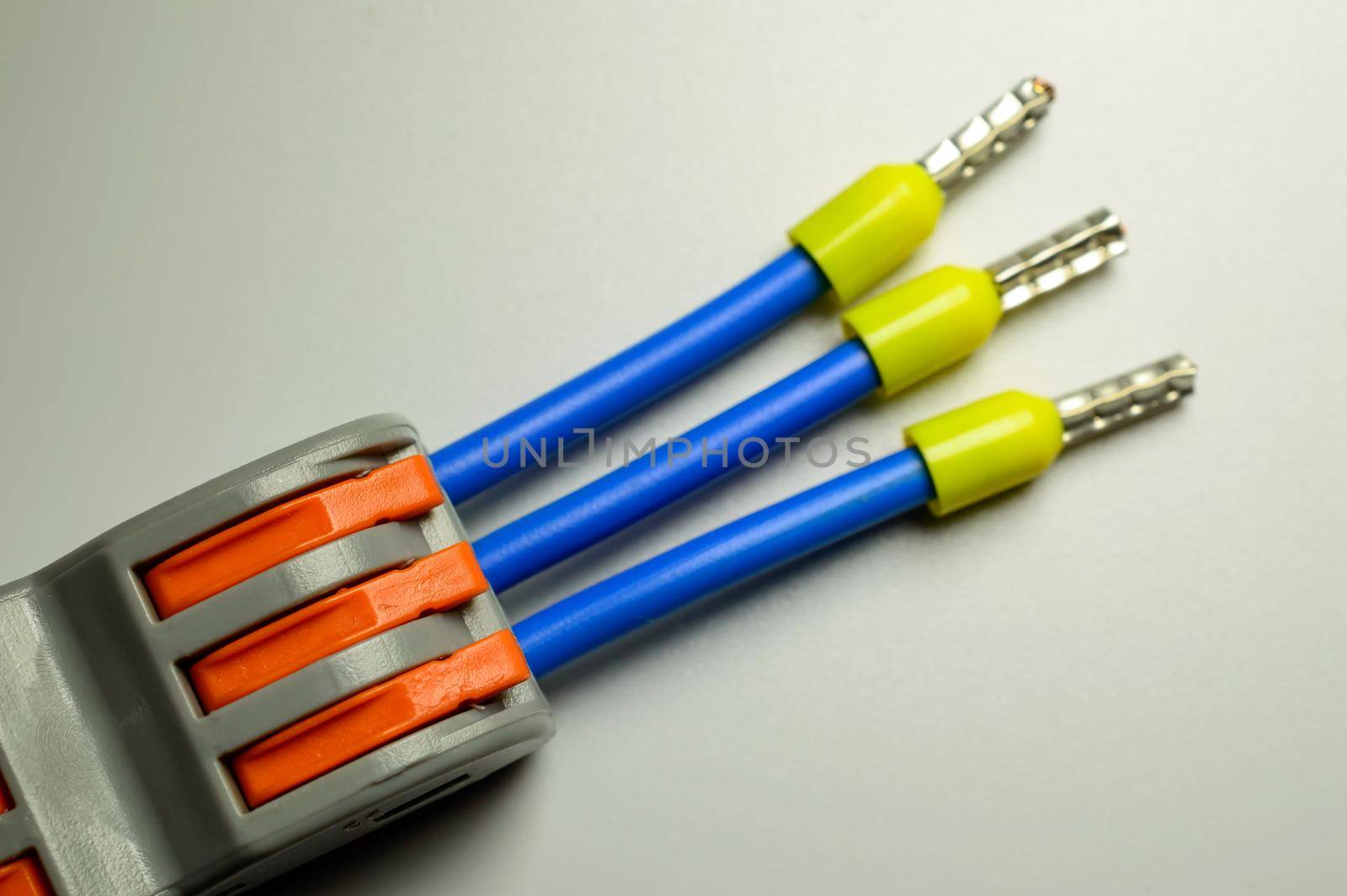 Electrical terminal for quick connection of wires with connected blue wires with yellow ferrules - macro photo. . High quality photo