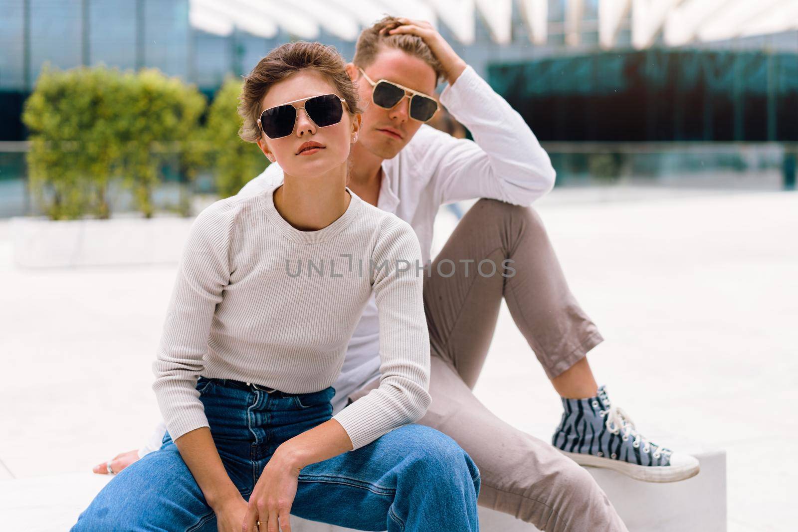 Young couple having problems in their relationship. man and woman friends in sunglasses sitting bench in city unhappy emotions. Relationships problem.