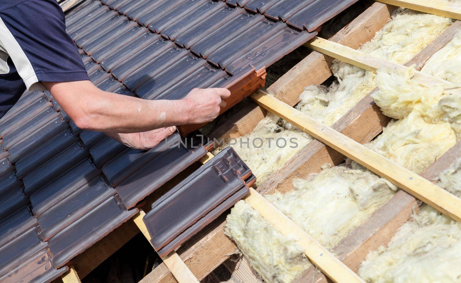 a roofer laying tile on the roof