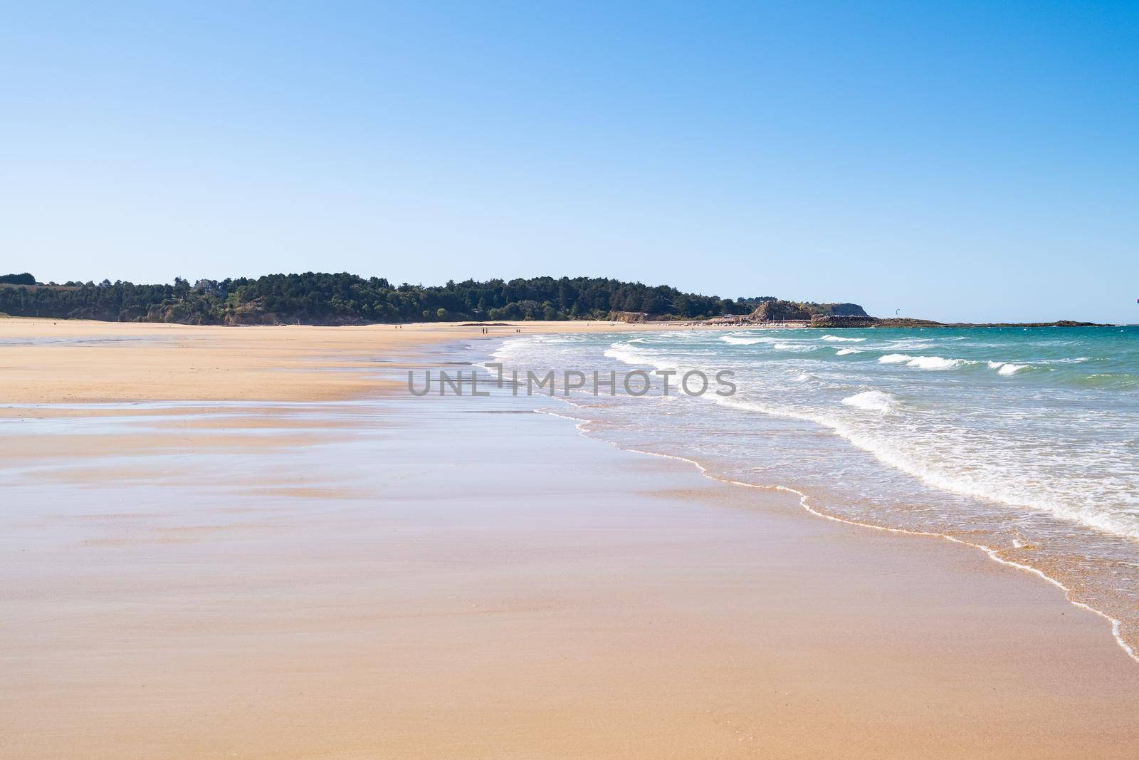 Large sandy beach in the town of "Sables d'or les pins" in Brittany at low tide in summer by jp_chretien
