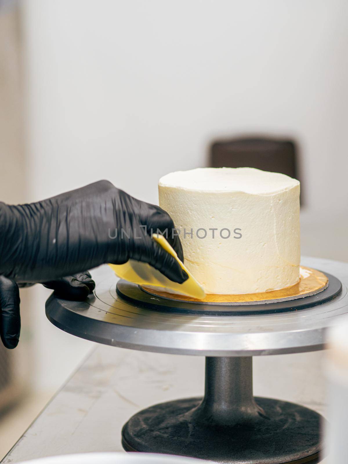 professional baker decorating a chocolate and cream cake with salty caramel