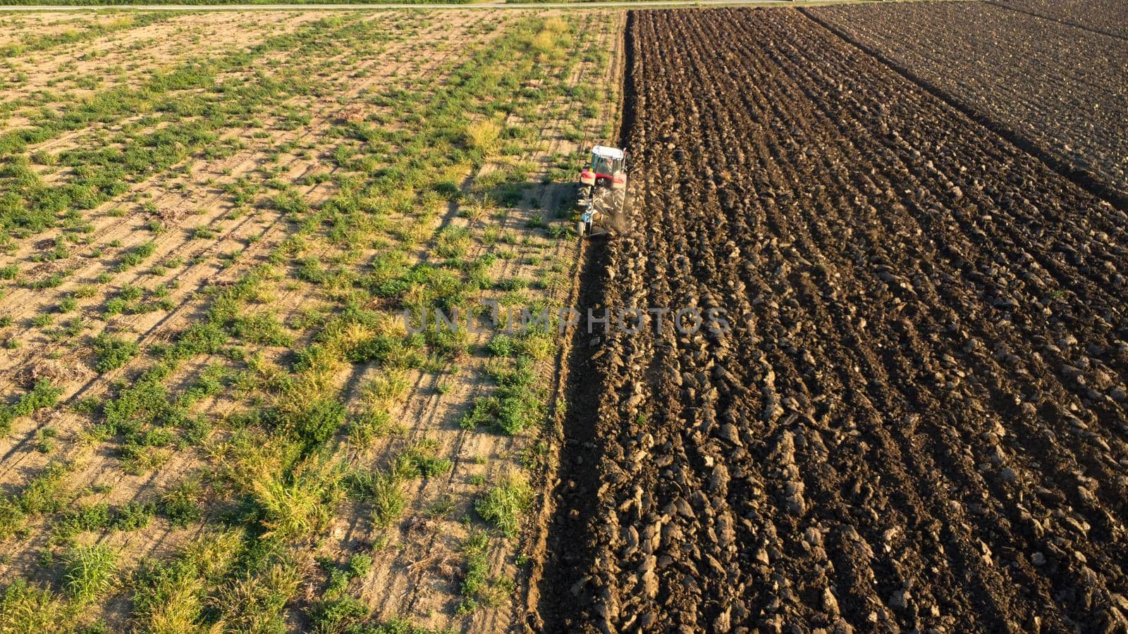 Aerial view with drone of tractor plowing the land in the countryside.