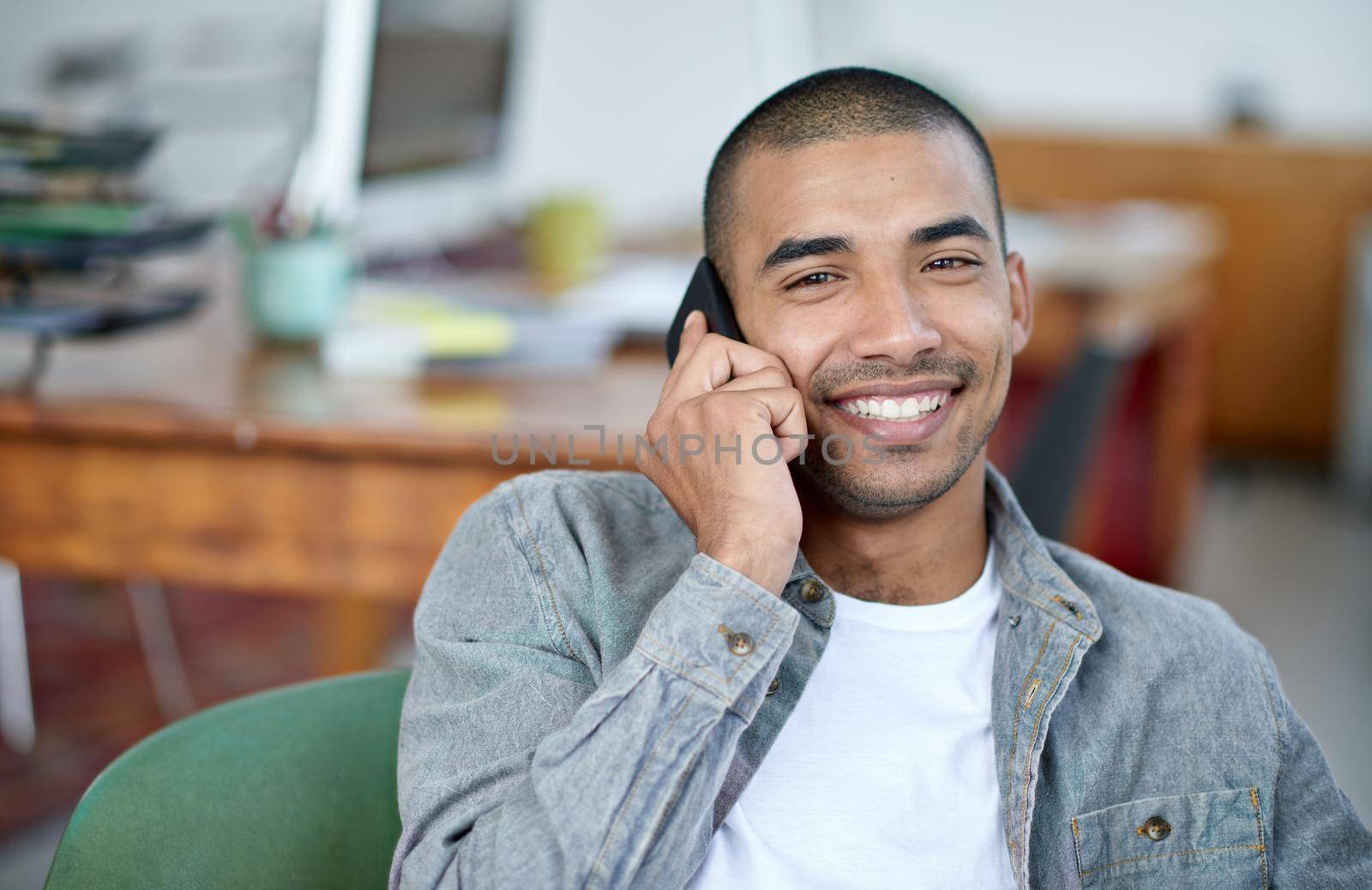 Communication gets the job done. Portrait of a handsome young office worker talking on a cellphone while sitting in an office