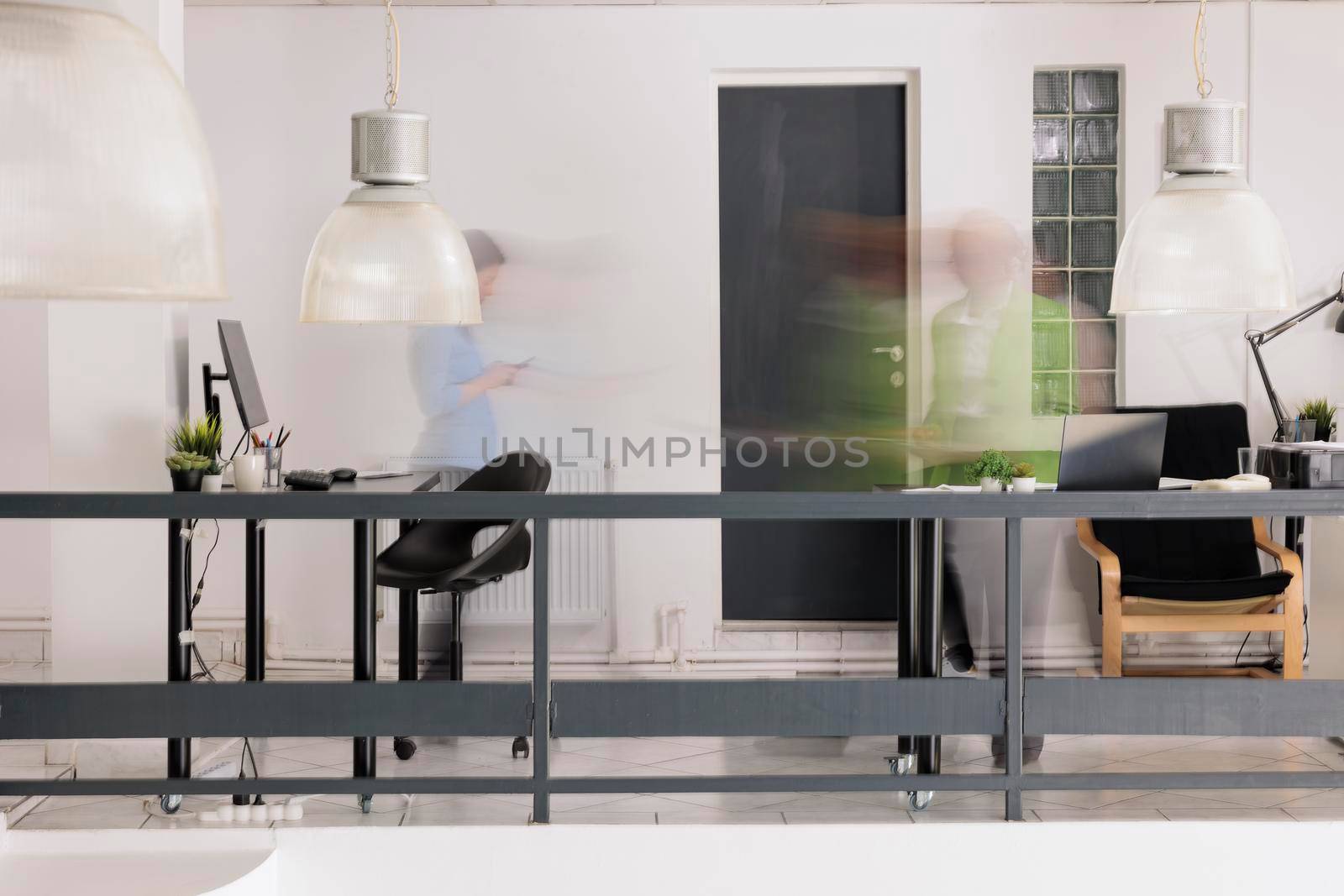 Blurred employees silhouettes walking in business coworking space in motion, long exposure effect. Company workers movement, startup office staff workday, work rush concept, wide shot