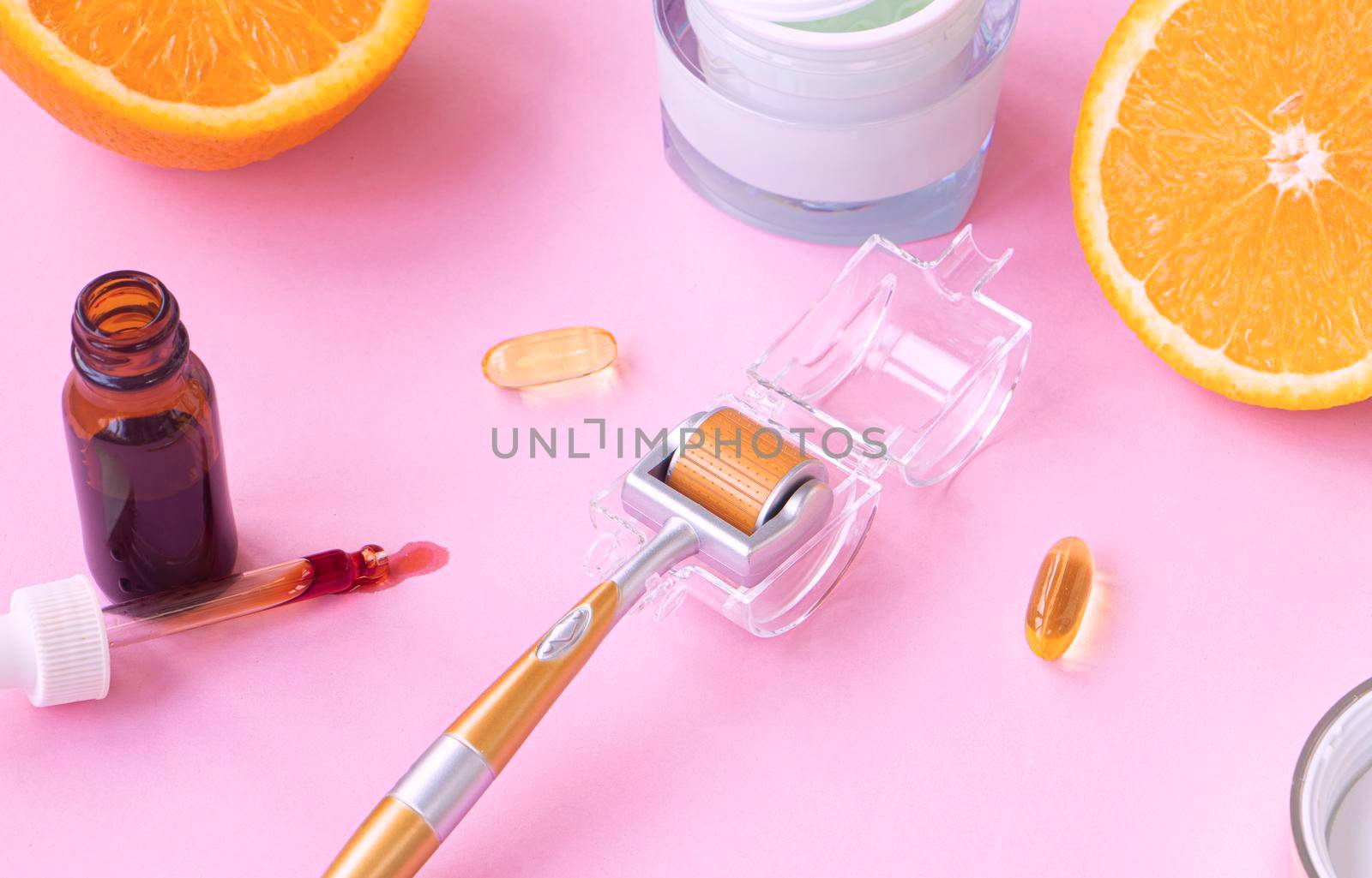 cosmetic instrument for microdermabrasion. background of open face serum spilled from a pipette. Face cream and citruses in the background. Vitamin C concept in skin care, cosmetics and cosmetology.