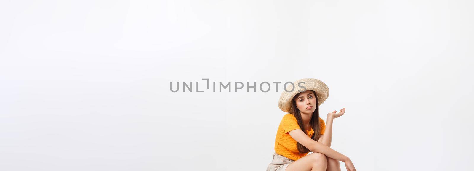 Lifestyle and travel Concept: Young beautiful caucasian woman is sitting on suitecase and waiting for her flight.Isolated over white background.