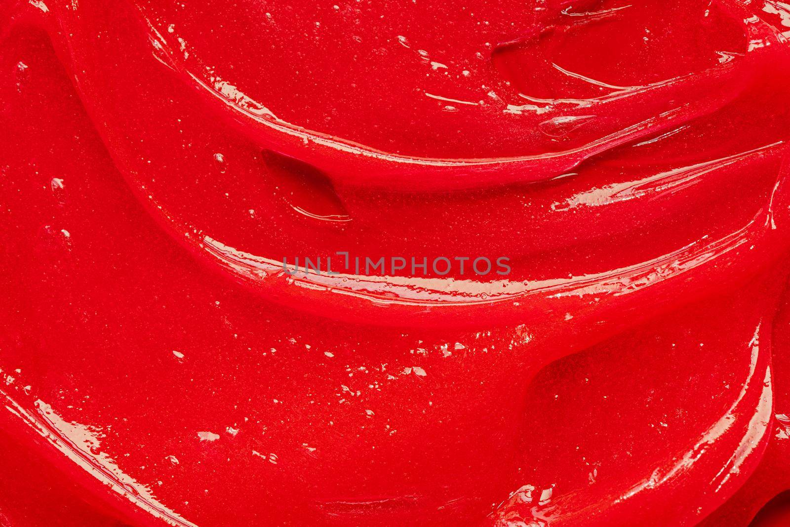 Red gel texture. Cosmetic clear liquid cream smudge. Skin care product sample closeup. Toothpaste or wax by photolime