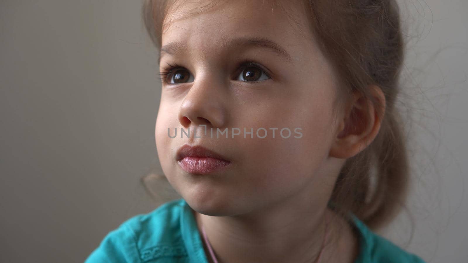 Portrait Funny little close up view happy preschool girl smiling child looking away thoughtfully, pretty natural face.sincere emotions of ashamed, embarrassed clean skin dermatology, pediatric dentistry. by mytrykau