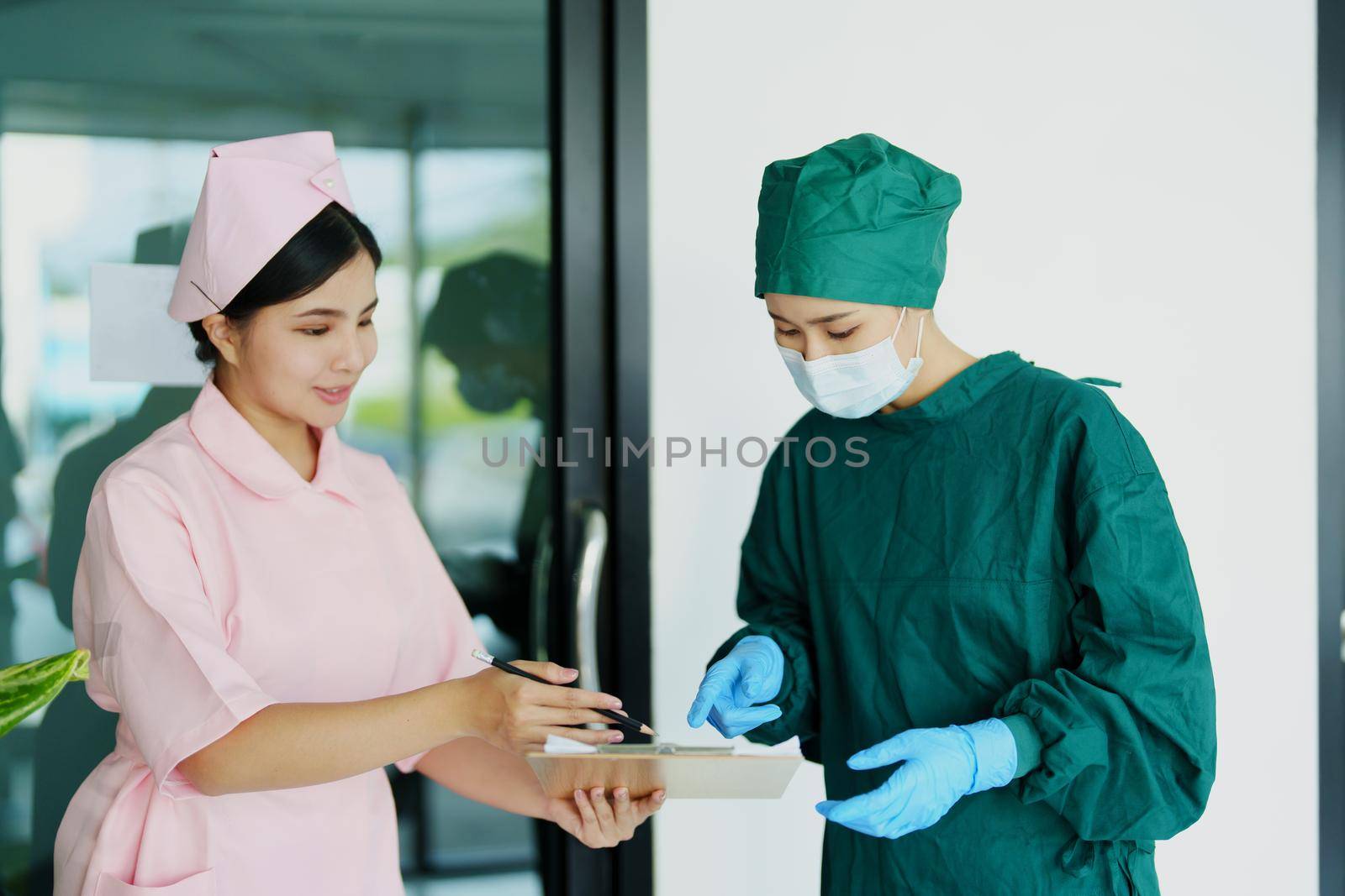 doctor and nurse talking before going into the operating room. by Manastrong