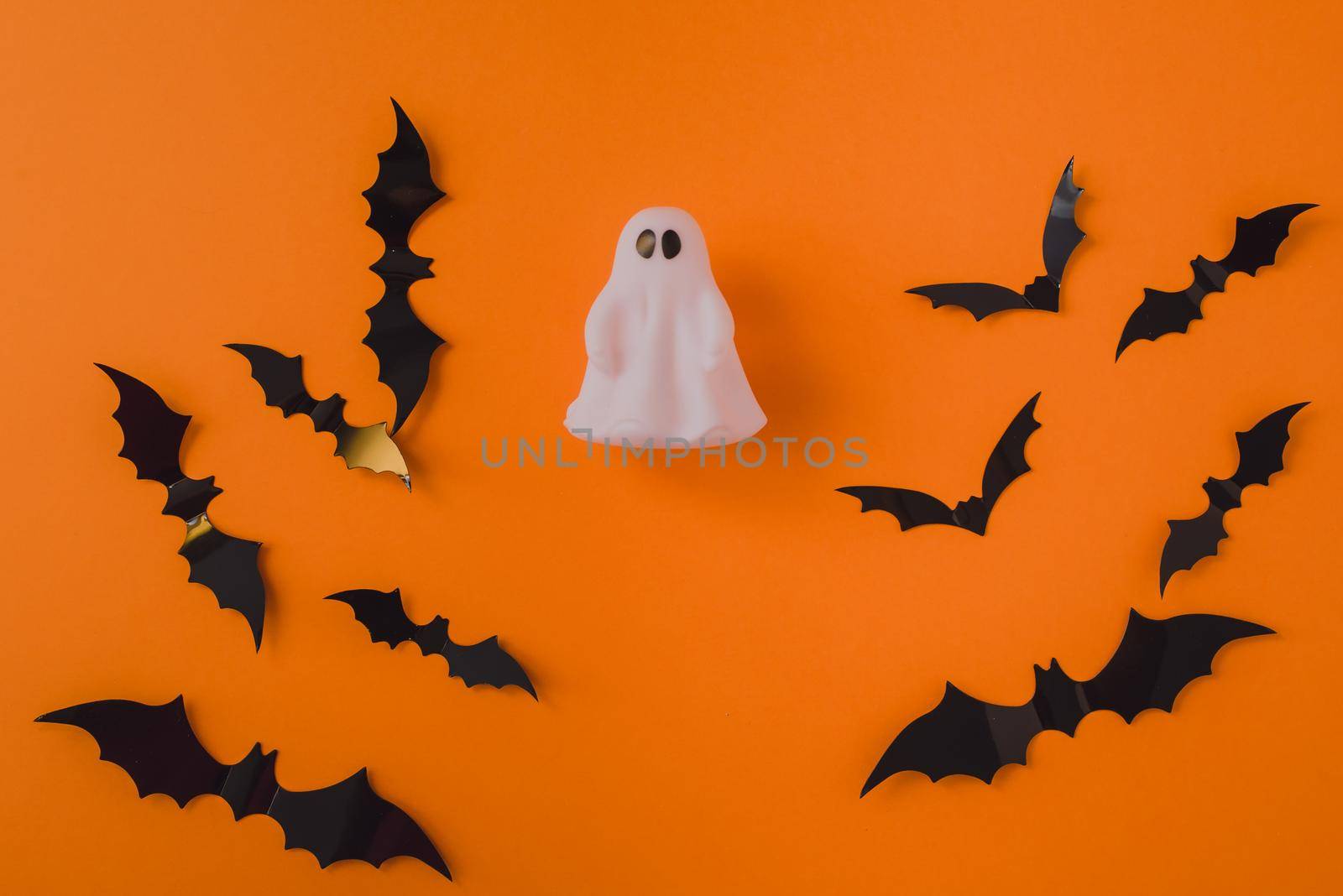Ghost on the background of bats on an orange background. Place for your text by etonastenka