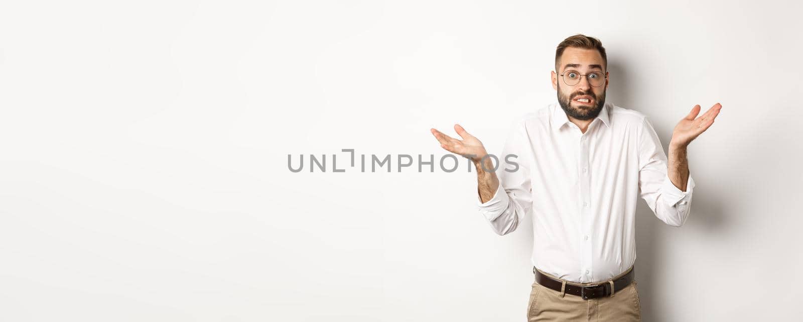 Clueless worried manager shrugging, looking confused, standing over white background.