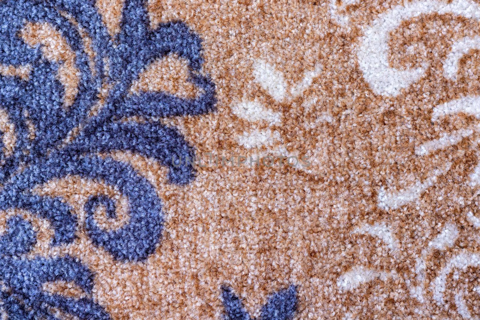 Light brown color carpet with blue and white color design texture background closeup view by Bilalphotos