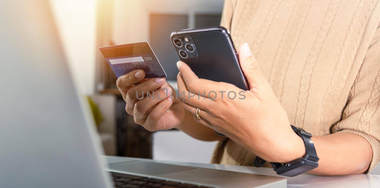 Woman hands holding credit card and smartphone with product purchase at home by Sorapop