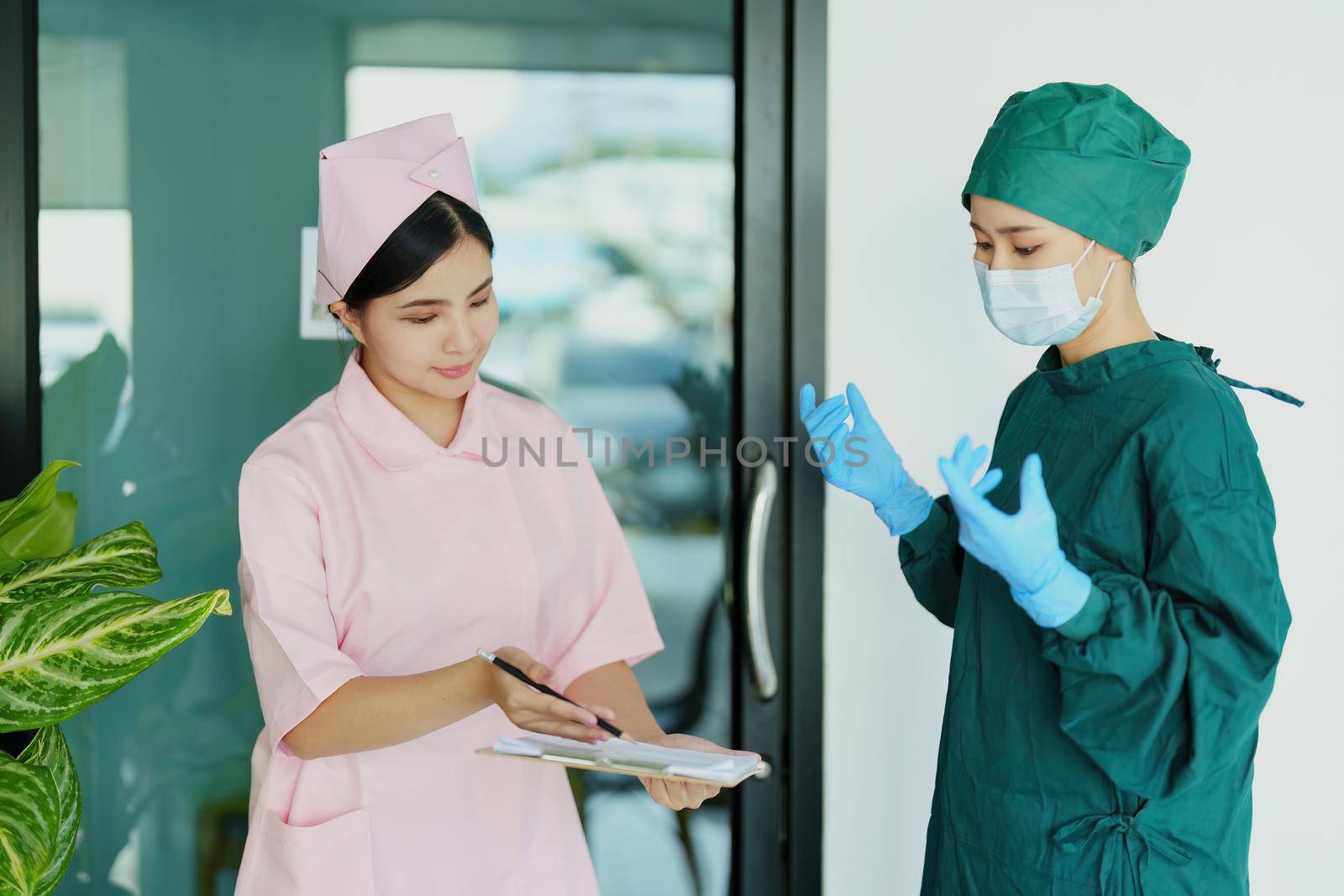 doctor and nurse talking before going into the operating room. by Manastrong