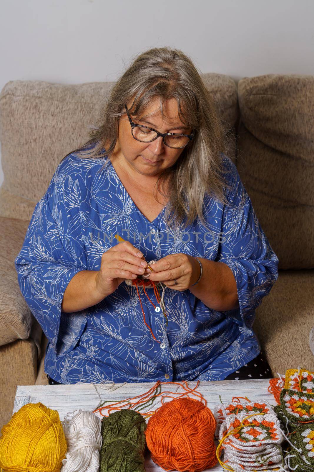 older white-haired woman crocheting by joseantona