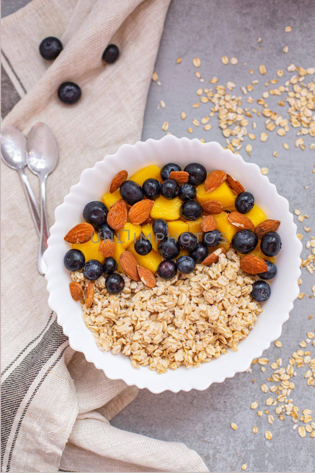 Bowl of oatmeal porridge with fresh fruits by Ciorba