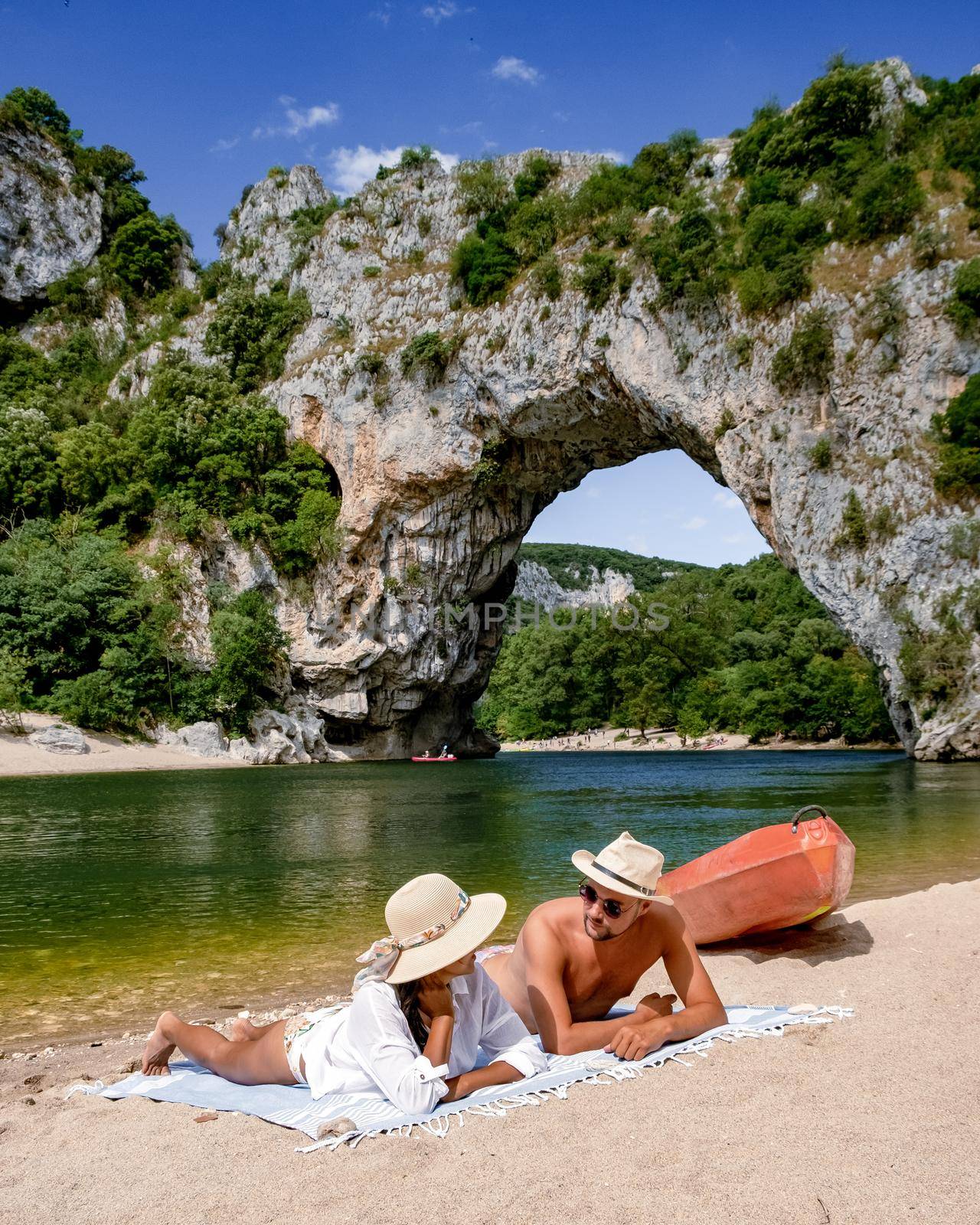 In Ardeche France, a couple of men and women picnic on the beach of The famous natural bridge of Pont d'Arc in the Ardeche department in France Ardeche. Europe Rhone Alpes