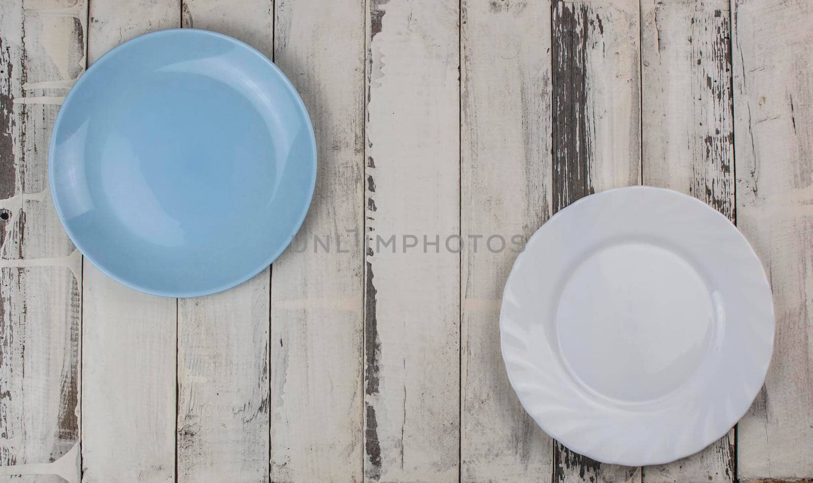 Top view of an empty ceramic plate on a rustic white wooden table
