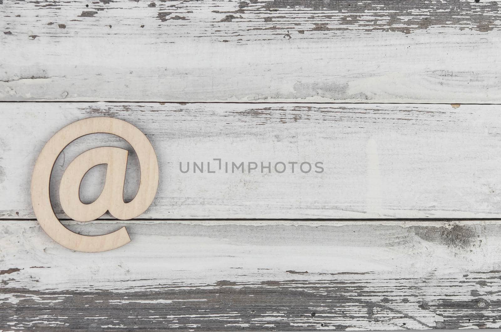 An email sign on a old white wood lies on a vintage wooden table. Concept e-mail message letter. Top view with copy space