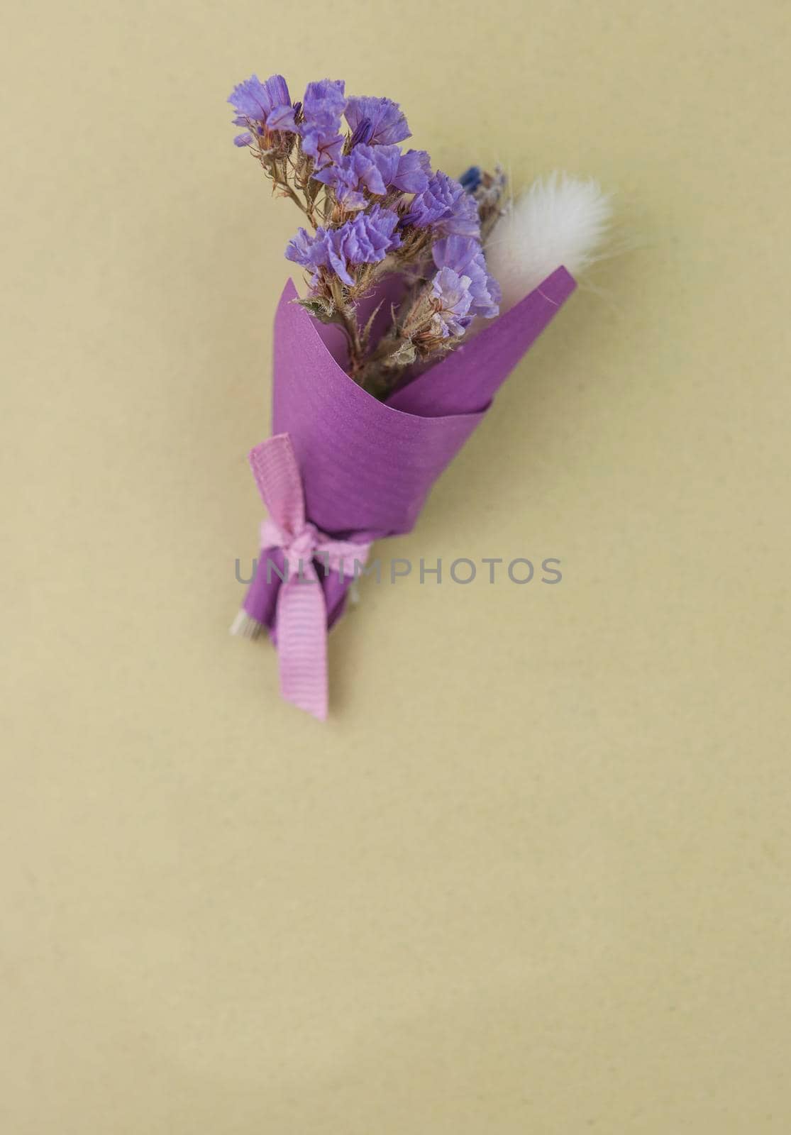 A bouquet of dried wild flowers with gift postcard on a white textured background made of antique wooden boards horizontal view from above by inxti