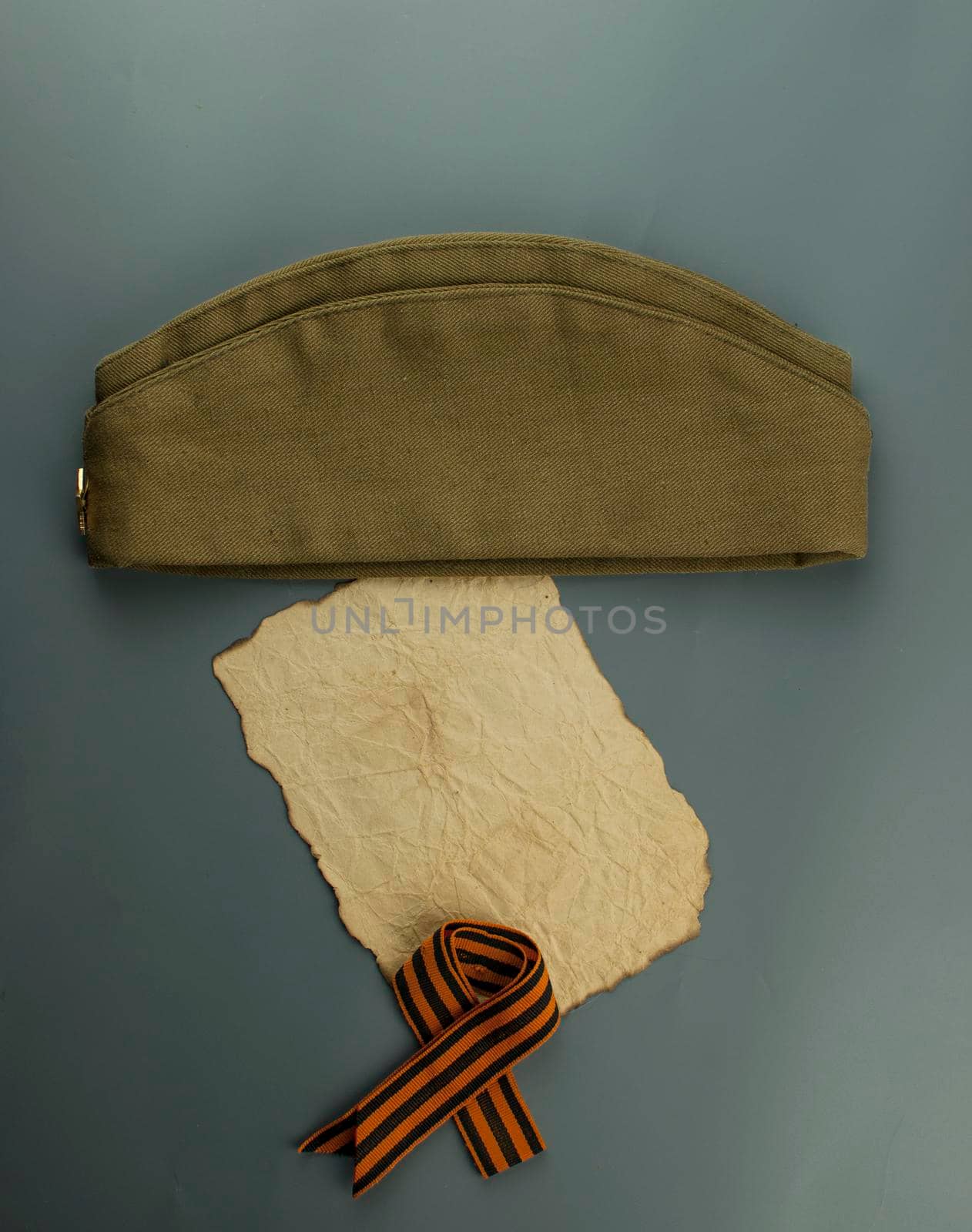 may 9 victory day holiday background. ribbon of St.George, burnt paper and military cap - traditional symbol of Victory Day 1945. greeting card design. copy space