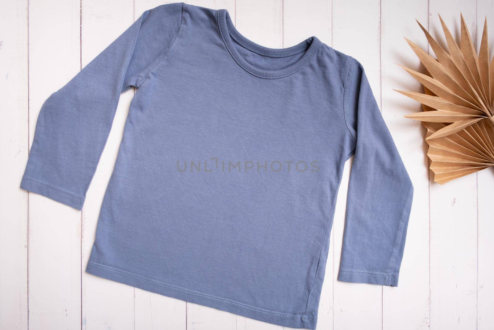 Grey baby shirt top view. Mock-up for logo, text or design on wooden background. Flat lay child clothers