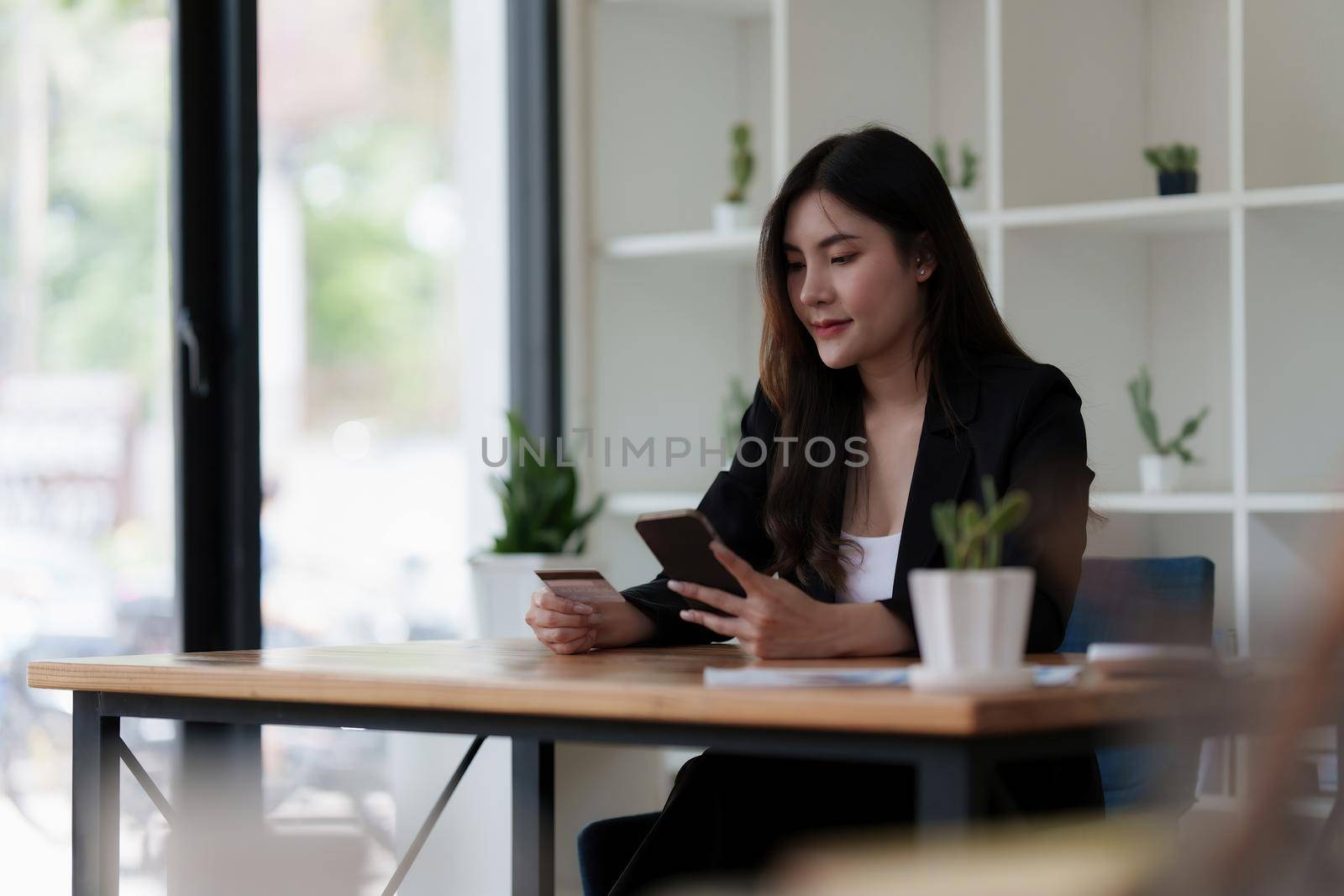 Young person using credit card and laptop computer. Online shopping, e-commerce concept.